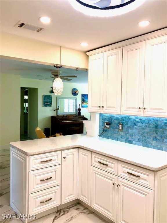 kitchen with white cabinetry, tasteful backsplash, kitchen peninsula, ceiling fan, and light tile patterned flooring