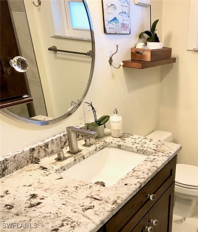 bathroom featuring toilet and vanity