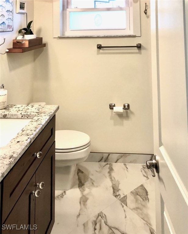 bathroom featuring tile patterned floors, vanity, and toilet