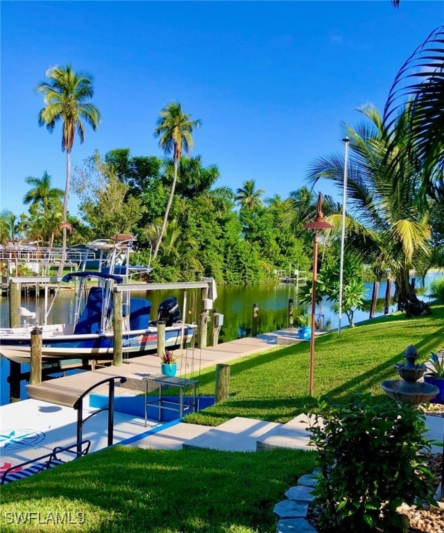 view of dock with a yard and a water view