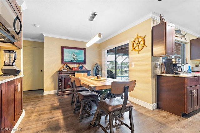 dining area with crown molding and hardwood / wood-style floors