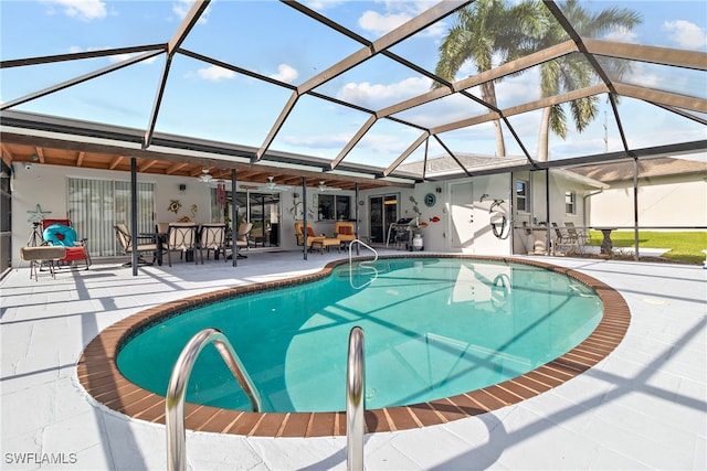 view of swimming pool featuring ceiling fan, a lanai, and a patio area