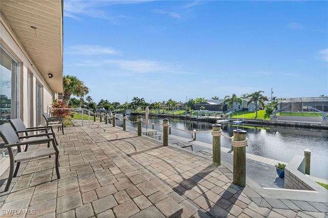 view of patio with a lanai, a water view, and a boat dock