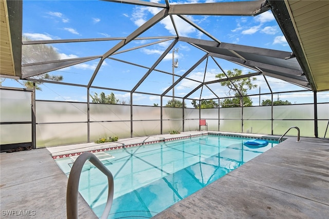 view of pool with glass enclosure and a patio area