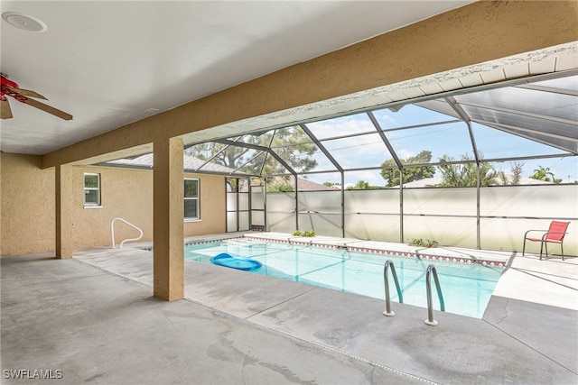 view of swimming pool featuring glass enclosure, ceiling fan, and a patio area