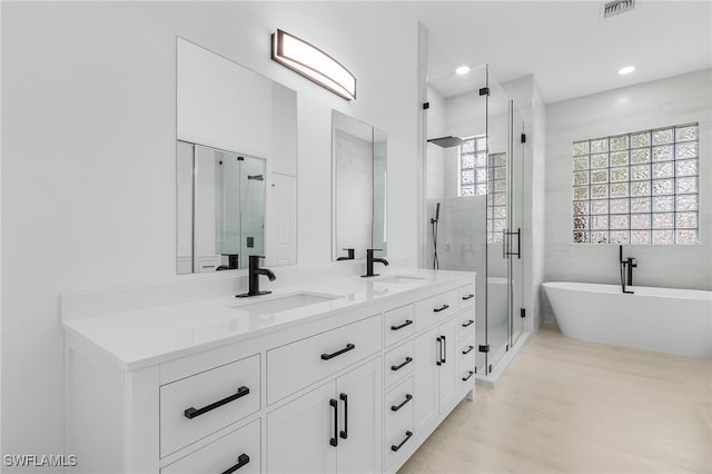 bathroom featuring hardwood / wood-style floors, vanity, and independent shower and bath