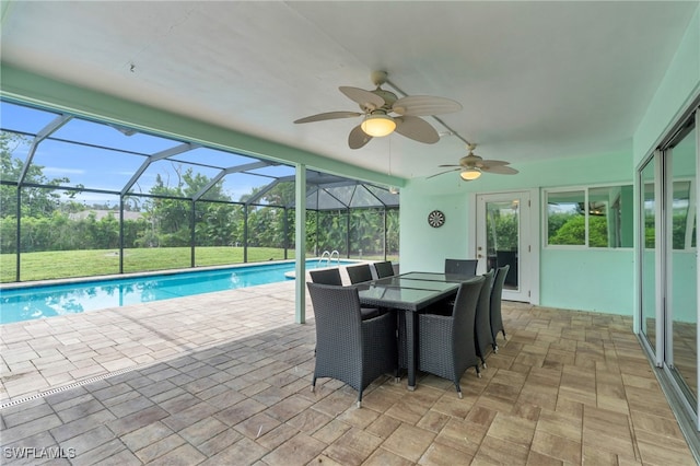 view of pool featuring glass enclosure, ceiling fan, and a patio