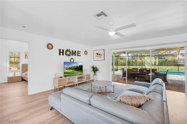 living room with light wood-type flooring and ceiling fan