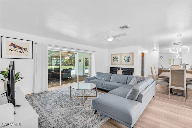 living room featuring a fireplace, light hardwood / wood-style flooring, and ceiling fan