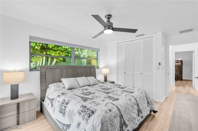 bedroom with light hardwood / wood-style flooring, ceiling fan, and a closet