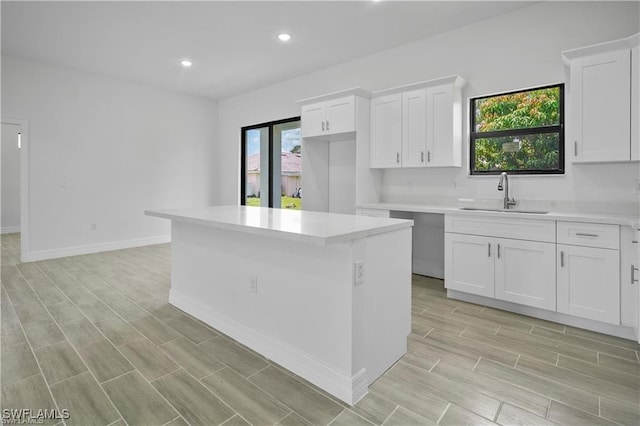 kitchen featuring a center island, white cabinetry, and sink