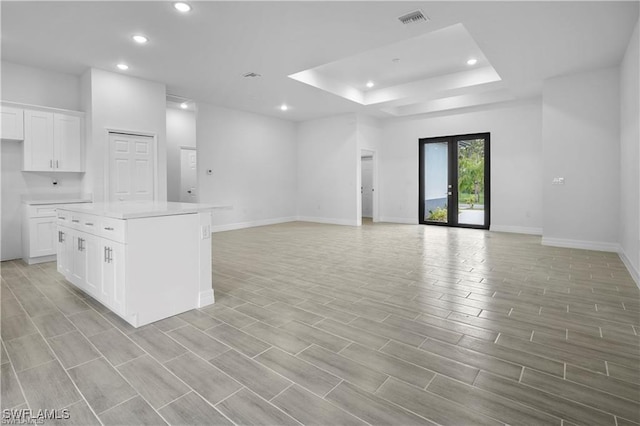 interior space with a raised ceiling and french doors