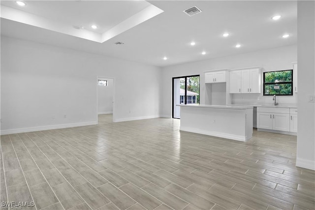 unfurnished living room featuring sink and light wood-type flooring