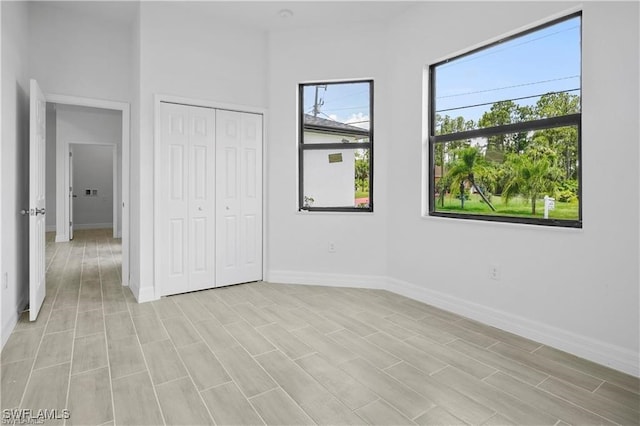 unfurnished bedroom with light wood-type flooring and a closet