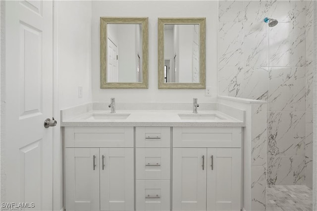 bathroom with a tile shower and vanity