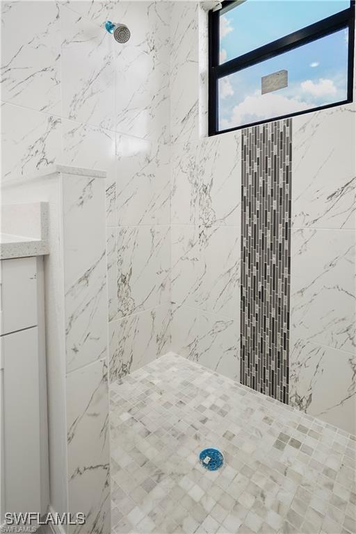 bathroom featuring vanity and tiled shower