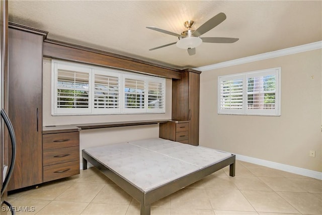 bedroom featuring light tile patterned floors, baseboards, ornamental molding, and ceiling fan