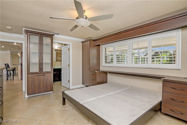 bedroom with crown molding, light tile patterned flooring, and a textured ceiling