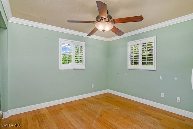 unfurnished room with a ceiling fan, baseboards, crown molding, and wood finished floors