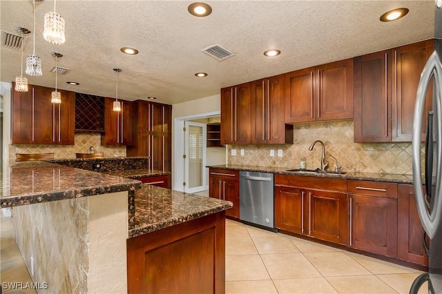 kitchen with stainless steel appliances, a sink, visible vents, hanging light fixtures, and dark stone counters