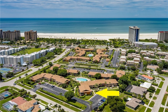 drone / aerial view featuring a view of the beach, a water view, and a city view