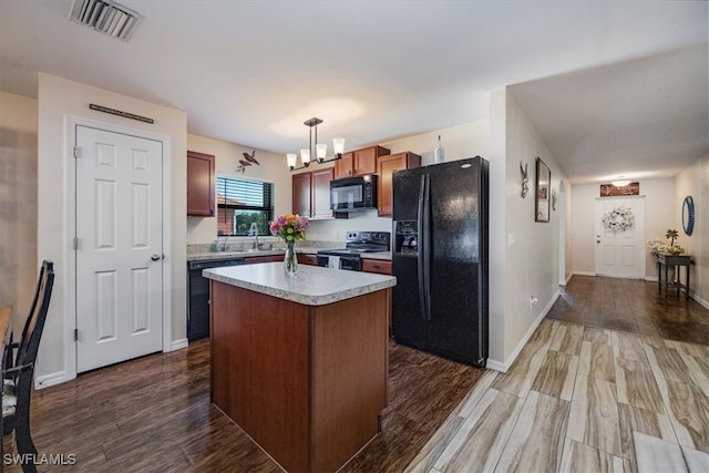 kitchen featuring a kitchen island, dark hardwood / wood-style flooring, black appliances, hanging light fixtures, and sink