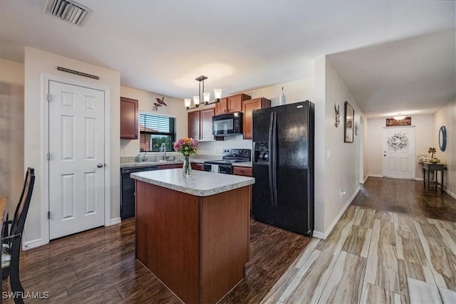 706 SW 9th Ct, Cape Coral, FL 33991 - kitchen featuring black appliances, a chandelier, light countertops, hanging light fixtures, and dark wood finished floors