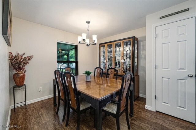 dining space with dark wood-type flooring and an inviting chandelier