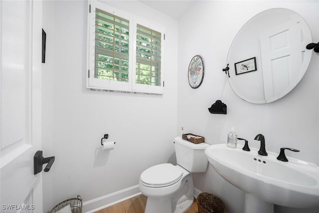 bathroom featuring sink, hardwood / wood-style floors, and toilet