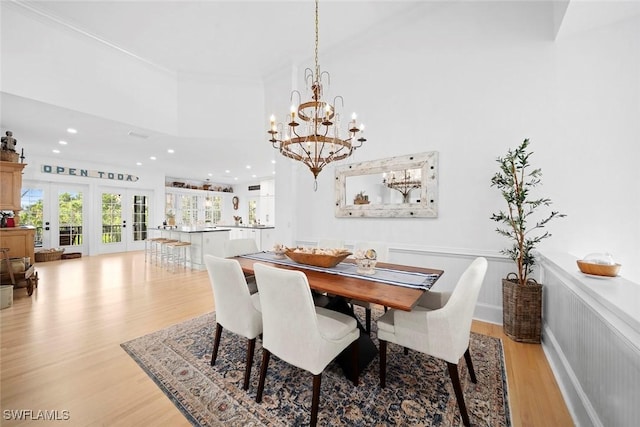 dining room with french doors, a notable chandelier, and light hardwood / wood-style floors