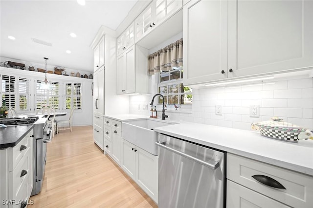 kitchen with light hardwood / wood-style floors, plenty of natural light, white cabinetry, and appliances with stainless steel finishes