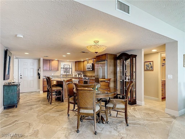 dining area featuring a textured ceiling, recessed lighting, visible vents, baseboards, and marble finish floor