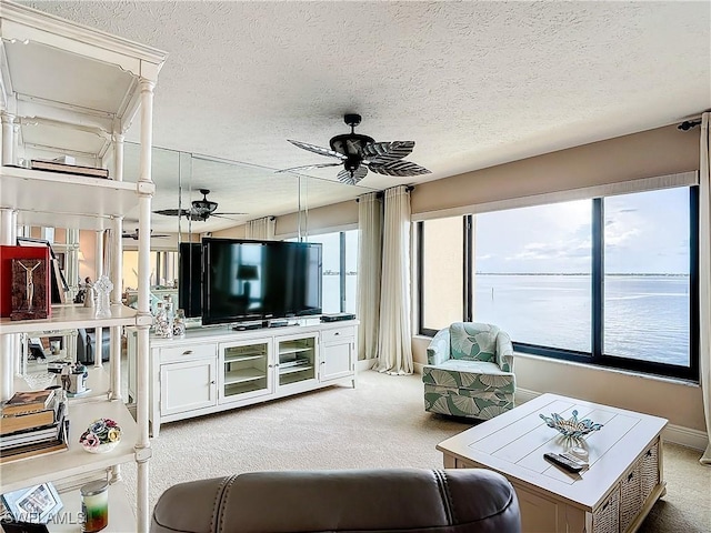 living room featuring light carpet, a textured ceiling, and a ceiling fan