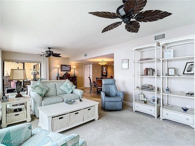 living room with a textured ceiling, visible vents, and a ceiling fan