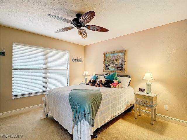 bedroom with carpet floors, ceiling fan, baseboards, and a textured ceiling