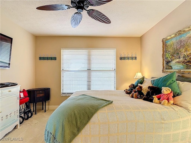 bedroom featuring light carpet, a textured ceiling, a ceiling fan, and baseboards