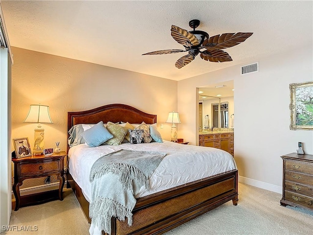 bedroom with ceiling fan, connected bathroom, light colored carpet, visible vents, and baseboards