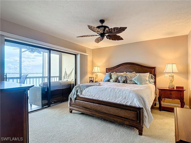 bedroom featuring light carpet, ceiling fan, a textured ceiling, and access to exterior