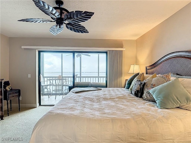 carpeted bedroom featuring access to exterior, a ceiling fan, baseboards, and a textured ceiling