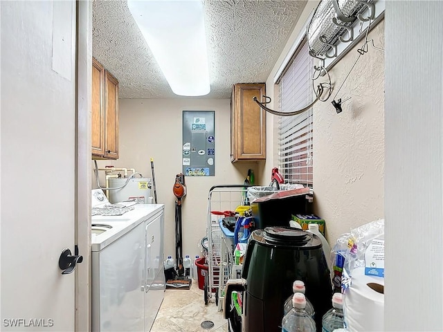 laundry room with water heater, cabinet space, a textured ceiling, and washer and dryer