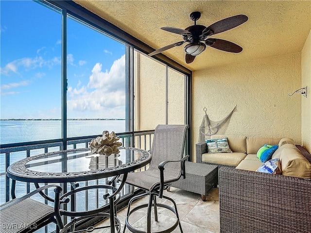 sunroom / solarium with a water view and a ceiling fan