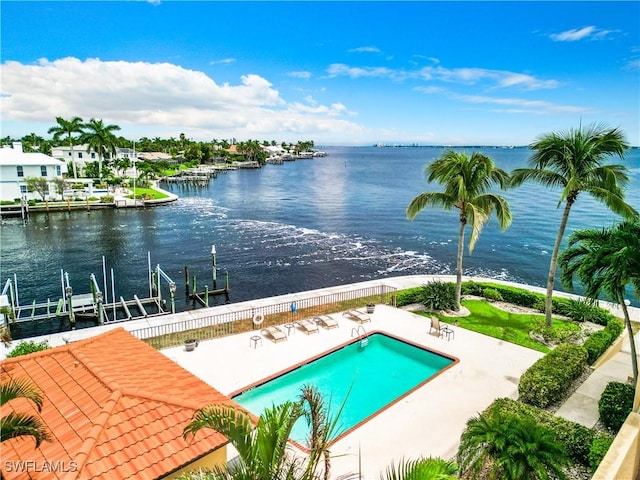 community pool with a patio area, a boat dock, a water view, and boat lift