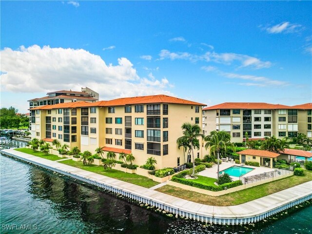 view of property featuring a water view and a community pool