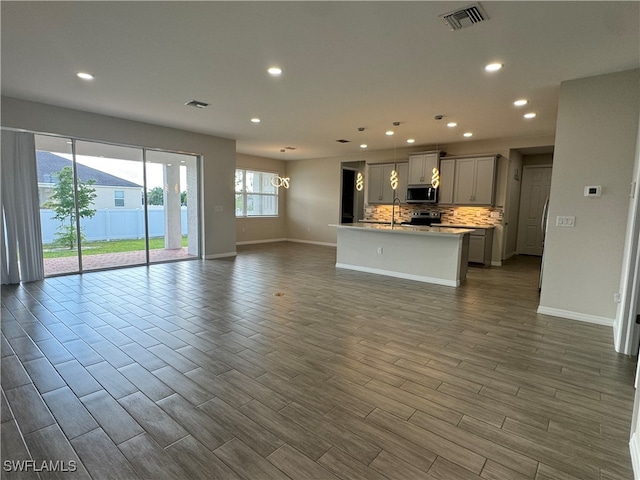 unfurnished living room featuring hardwood / wood-style flooring and sink