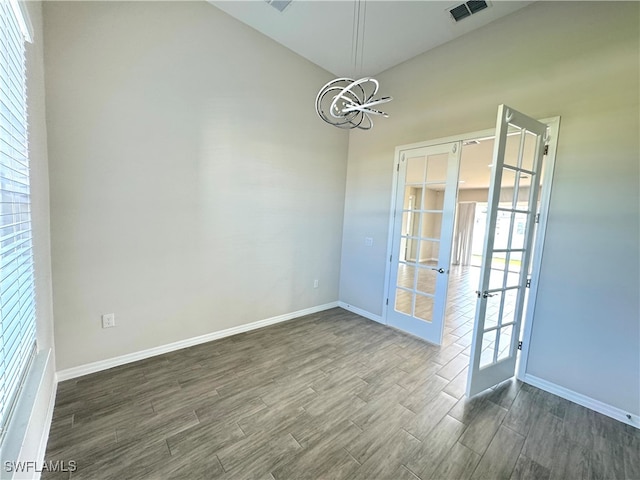 empty room featuring dark hardwood / wood-style flooring and french doors