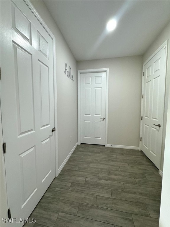 corridor with dark hardwood / wood-style flooring