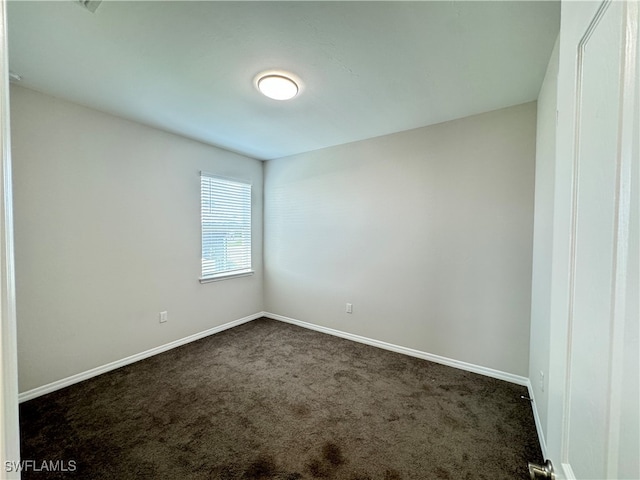 empty room featuring dark carpet