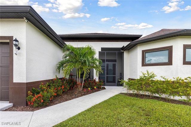 view of exterior entry with a yard