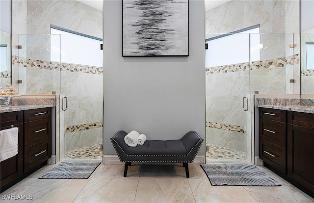 bathroom with a shower with door, tile patterned floors, and vanity