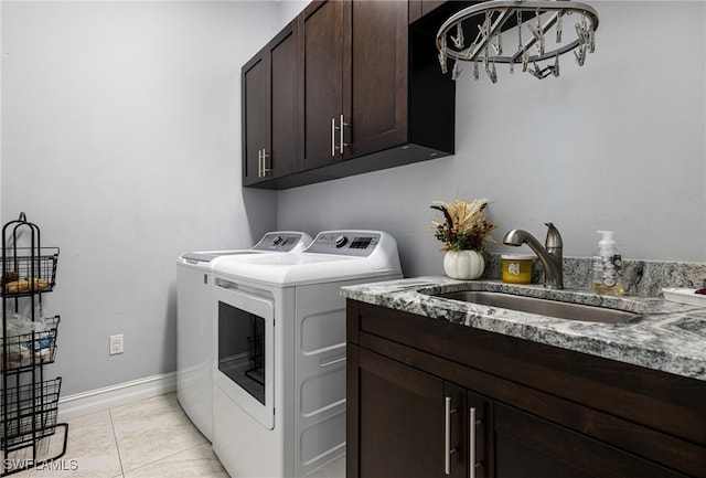 laundry room with sink, washing machine and clothes dryer, cabinets, and light tile patterned flooring